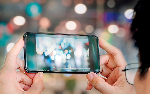 Pessoa assistindo vídeo no celular faz alusão a taxa de retenção de um conteúdo